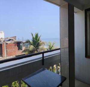 a balcony with a table and a view of the ocean at Ajantha Beach Guest House in Pondicherry