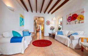 a living room with two white couches and a red rug at Puresa in Artá