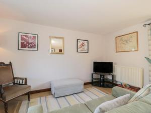 a living room with a couch and a tv at The Cowshed in Bristol