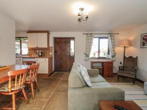 a living room with a couch and a table at The Cowshed in Bristol