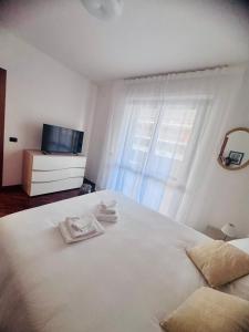 a bedroom with a white bed and a television at Domus Leonardo Apartment in Fiumicino Airport
