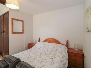 a bedroom with a bed and a dresser with a bedspread at The Cowshed in Bristol