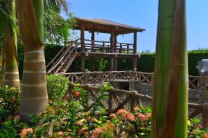 a wooden observation tower in a garden with flowers at Ginger Kheda, Ahmedabad in Kheda