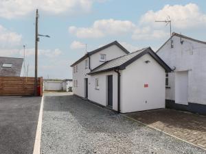 a row of white buildings in a parking lot at Kiloran in Rhosneigr