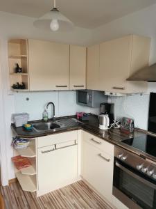a kitchen with white cabinets and a sink at Schöne Ferienwohnung Wetzlar in Wetzlar