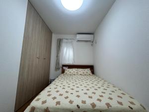a small bedroom with a bed and a window at 新築江の電腰越駅前徒歩1分鎌倉江の島観光に最適鎌倉腰越駅前ｂ棟 in Kamakura