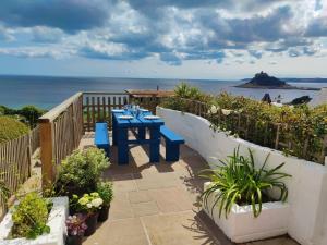 a blue table on a balcony with a view of the ocean at Ty Bryn in Marazion