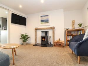 a living room with a fireplace and a blue couch at Ty Bryn in Marazion