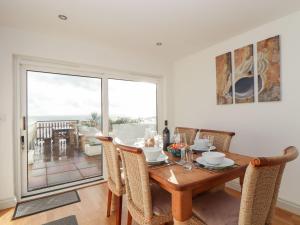 a dining room with a table and chairs and a window at Ty Bryn in Marazion
