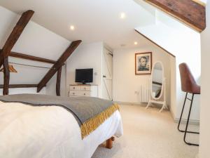a bedroom with a bed and a tv in it at Ty Bryn in Marazion