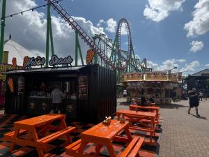 an amusement park with benches and a roller coaster at Sunnymede i15 Hot Tub - pet friendly, bed linen - Meadow Lakes Caravan & Lodge Hire in Ingoldmells
