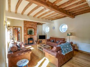 ein Wohnzimmer mit Ledermöbeln und einem Kamin in der Unterkunft Six Apples in Braintree