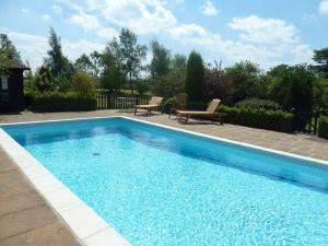 ein großer blauer Swimmingpool mit zwei Stühlen daneben in der Unterkunft Six Apples in Braintree