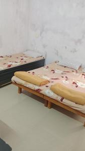 two beds are sitting in a room at vishranti bhawan in Dwarka