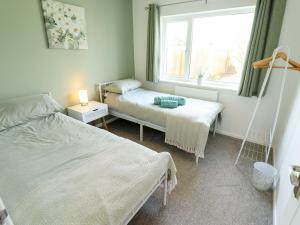 a bedroom with two beds and a window at Field View in North Walsham