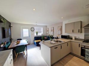 a kitchen and living room with a table and a counter top at Gatwick Cozy Stopover 4 bedroom house with free Parking in Copthorne +21 photos
