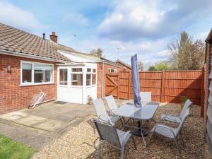 a patio with a table and chairs and an umbrella at Field View in North Walsham