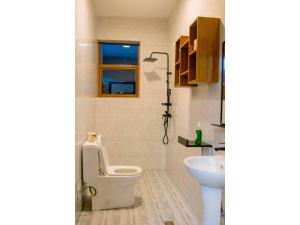 a bathroom with a toilet and a sink and a window at Residency by Mozette Kigali in Kigali +32 photos