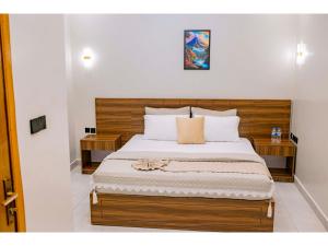 a bedroom with a large bed with a wooden headboard at Residency by Mozette Kigali in Kigali