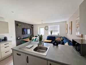 a kitchen and a living room with a couch at Gatwick Cozy Stopover 4 bedroom house with free Parking in Copthorne