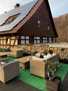 a woman sitting on a couch in front of a barn at Nowa Prowansja in Chrośnica