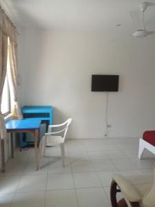a living room with a blue table and a television at J and M Pension House in Dipolog