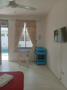 a living room with a blue table and a tv at J and M Pension House in Dipolog