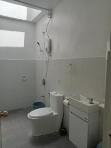 a white bathroom with a toilet and a sink at J and M Pension House in Dipolog
