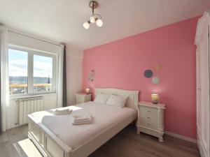 a bedroom with a white bed and a pink wall at Inima Iasului - Central View Apartment in Iaşi