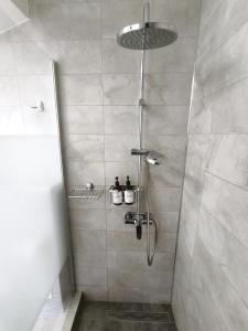 a bathroom with a shower with a glass door at Inima Iasului - Central View Apartment in Iaşi +24 photos