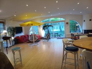a living room with a yellow umbrella and tables and chairs at Villa Roma in Montluçon