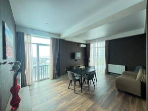 a living room with a table and chairs and a couch at Airport Hotel Apartments in Tbilisi City
