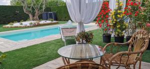 a patio with a glass table and chairs and a pool at Manor Villa Among Veneto's Orchards in Castelbaldo