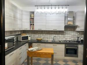 a kitchen with white cabinets and a wooden table at Manor Villa Among Veneto's Orchards in Castelbaldo