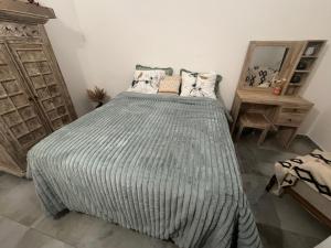 a bedroom with a bed with a striped comforter at Arche du cap de bonne esperance in Sainte-Rose