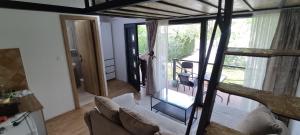 a living room with a couch and a large window at Iskra Tiny House in Podgorica