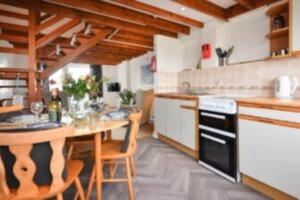 a kitchen with a table and a stove top oven at Cilan in Llangian