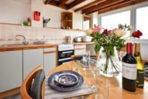 a kitchen with a table with a bottle of wine and flowers at Cilan in Llangian