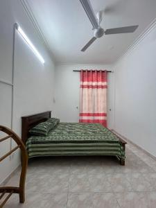 a bedroom with a bed and a ceiling fan at Johasham Villa in Colombo