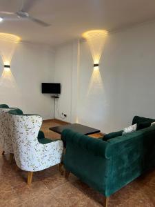 a living room with a green couch and a table and chairs at Johasham Villa in Colombo