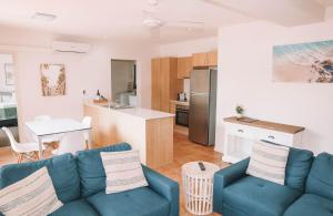 a living room with a couch and a kitchen at Yamba Beach Motel in Yamba