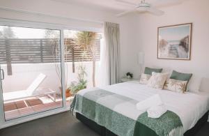 a bedroom with a large bed and a large window at Yamba Beach Motel in Yamba +19 photos