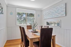 a dining room with a wooden table and chairs at Seabreeze Cottage in Manyana +19 photos