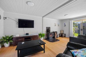 a living room with a couch and a tv at Seabreeze Cottage in Manyana