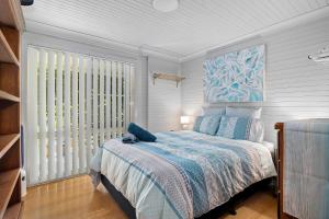 a bedroom with a bed and a large window at Seabreeze Cottage in Manyana