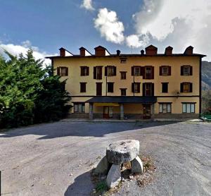 un banco de piedra frente a un gran edificio en Apartamentos Tuara, en El Run