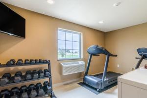 a gym with a treadmill and a flat screen tv at Cobblestone Inn & Suites - Oberlin in Oberlin