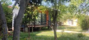 a house with a deck in the middle of trees at Iskra Tiny House in Podgorica