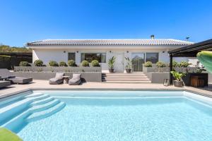 a swimming pool in front of a house at Solena Villa in Stavromenos