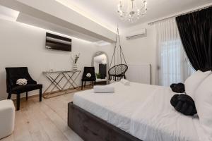 a bedroom with a bed and two chairs and a chandelier at Solena Villa in Stavromenos +40 photos